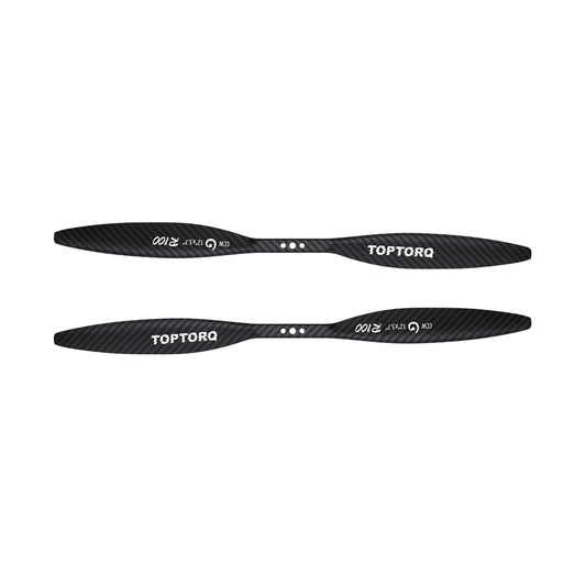 Two black carbon fiber drone propellers with white TOPTORQ branding, displayed horizontally against a solid white background.