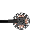 A close-up top-down view of a circular black and silver circular motor or sensor component with copper windings and a black cable entering from the left, shown on a plain white background.
