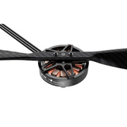 A close-up studio shot of a black drone motor with copper windings and a black carbon fiber propeller, on a solid white background. The brand 'SilencerTech' is visible on the motor's casing.