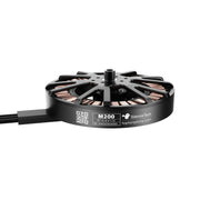 A black Silentech M200 brushless motor with copper windings and a black cable, shown on a clean white background.
